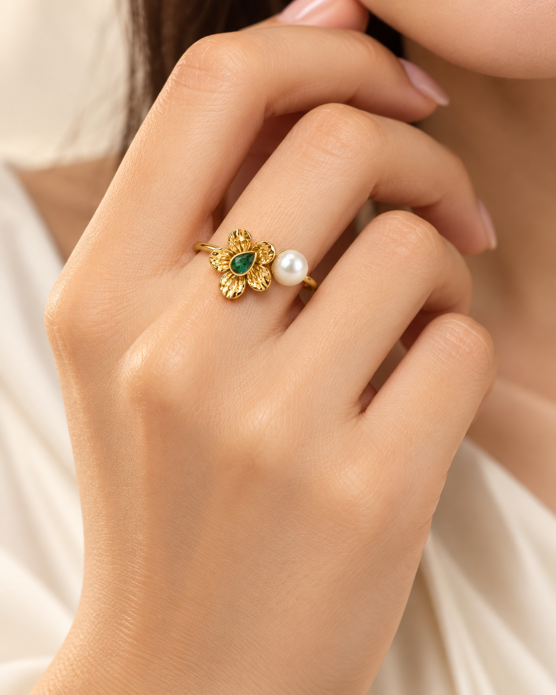 Pearl Bloom Ring detail, green pear cut bezel set at the centre of a textured gold flower