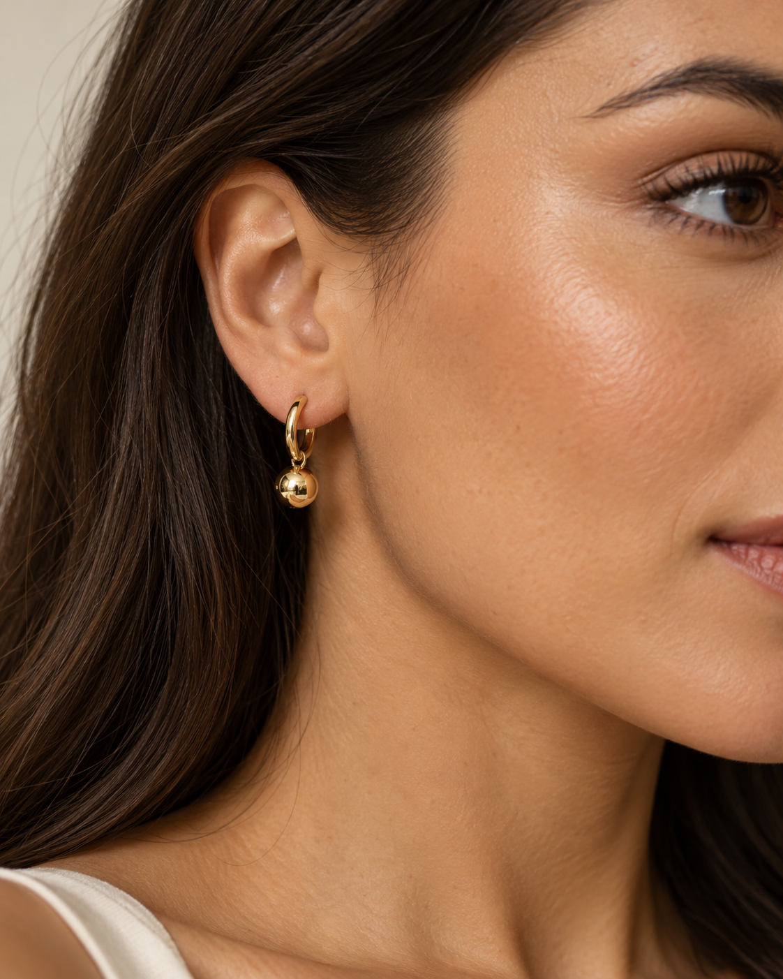 Ball Drop Huggie Earrings, a smooth gold tone sphere hanging from a small hoop